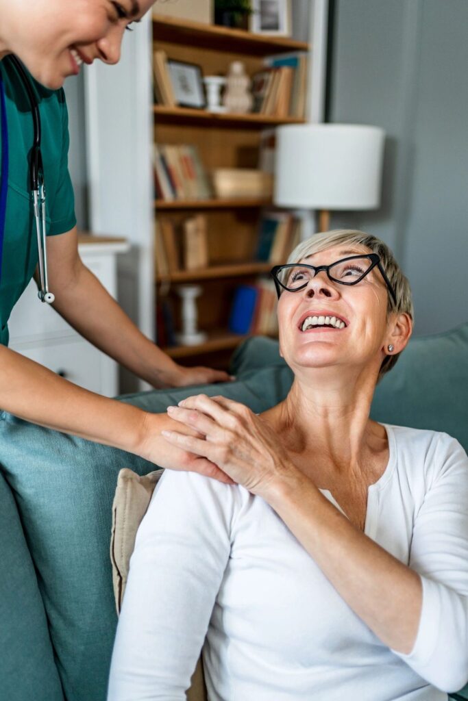 Nurse comforting a senior woman at home